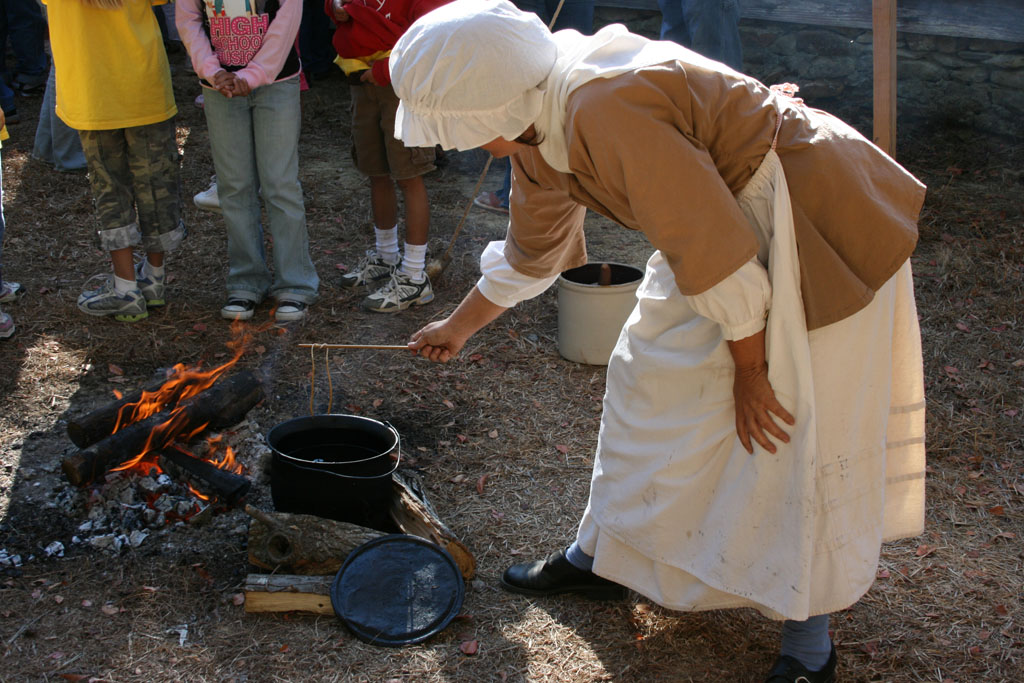 A reenactor demonstrates candlemaking at Alamance Battleground.